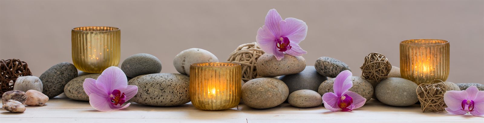 Spa stones, candles and orchids laid out in a row