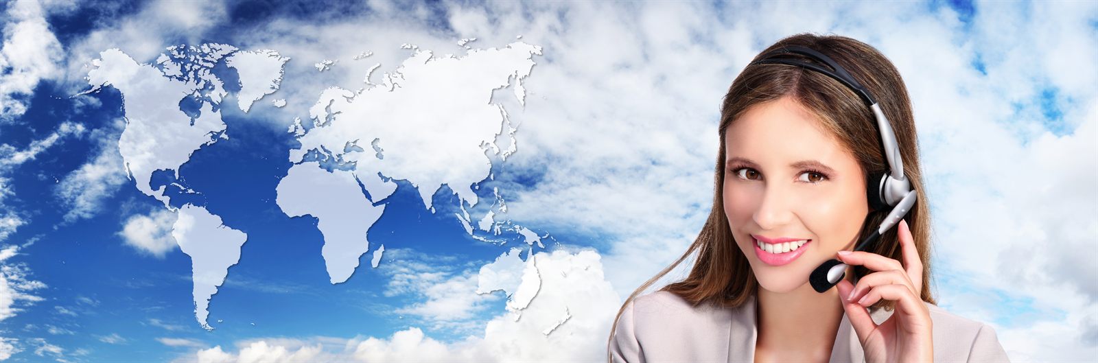 Smiling travel advisor wearing a headset beside a world map in the clouds