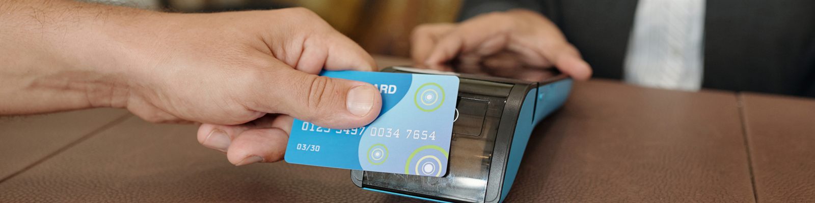 Hand paying with a card at a payment terminal