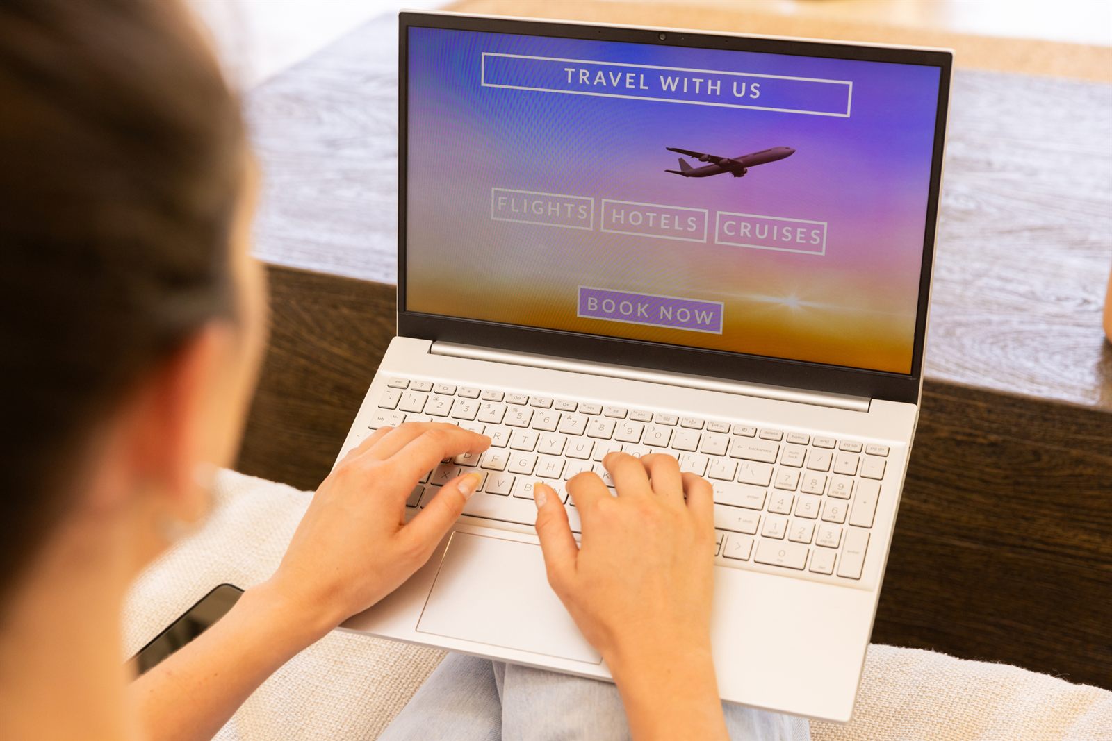 Traveler typing on a laptop showing a travel booking page